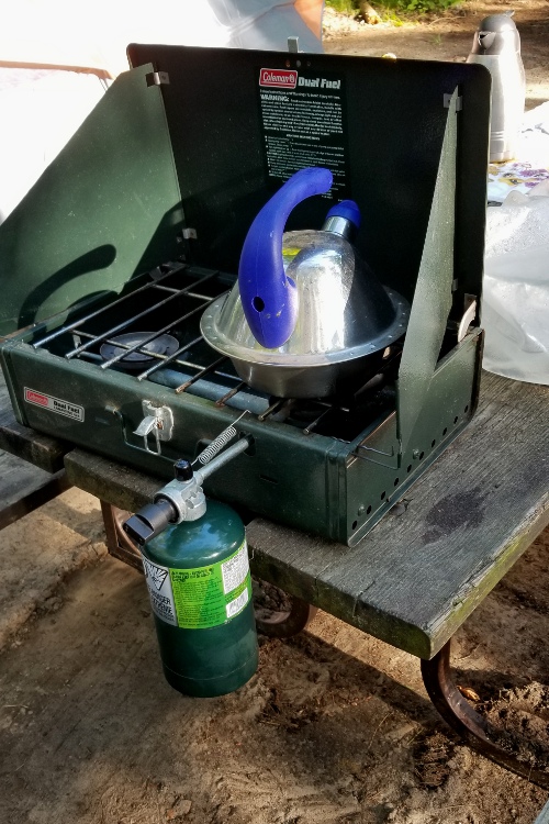 My camp stove with my kettle, the water boiling and ready to make my morning coffee.